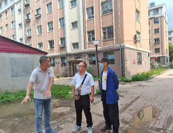针对部分小区路面破损问题，东盛社区网格员申传义与小区热心居民共同商讨破损路面修补方案。.jpg